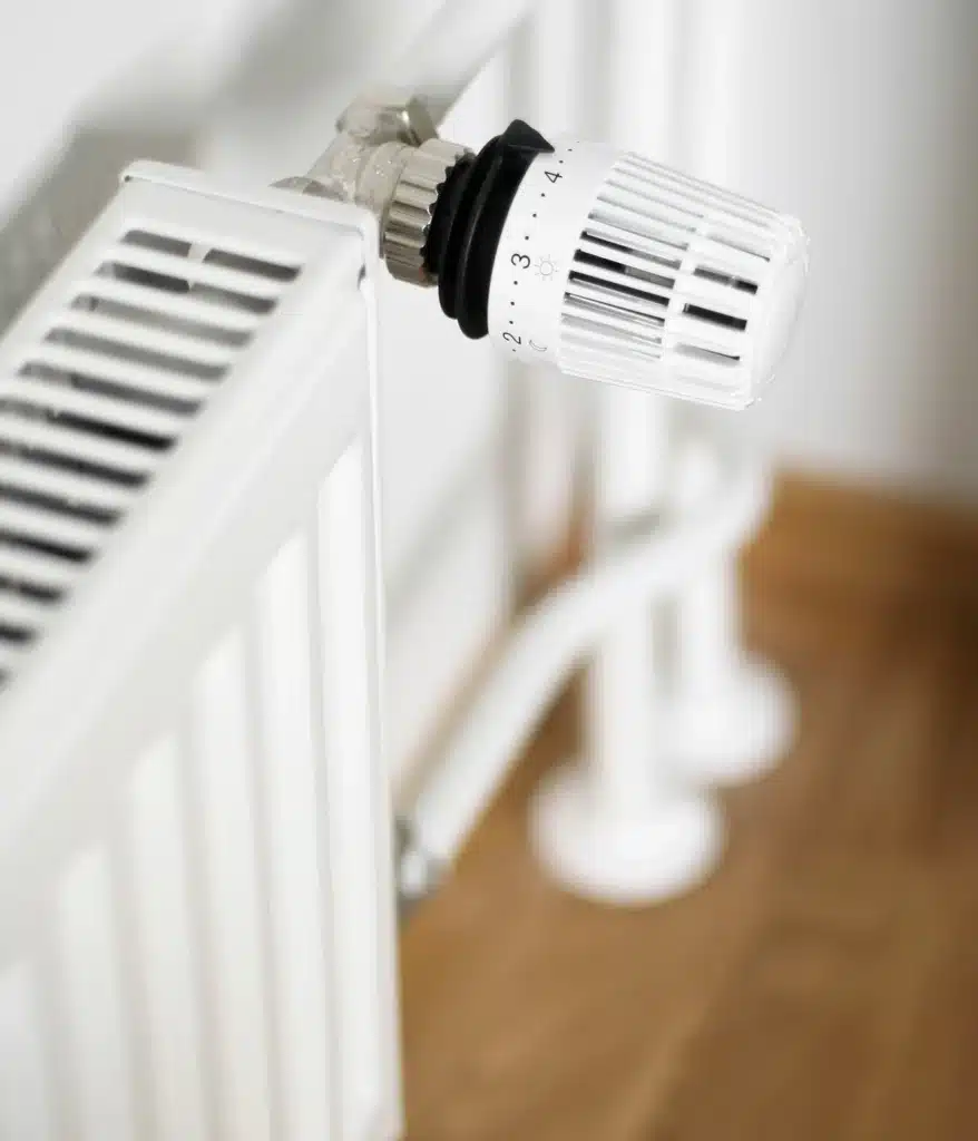 Réglage du chauffage : Vanne thermostatique sur radiateur Vanne thermostatique blanche sur un radiateur, réglée sur 3 avec les symboles soleil et lune.